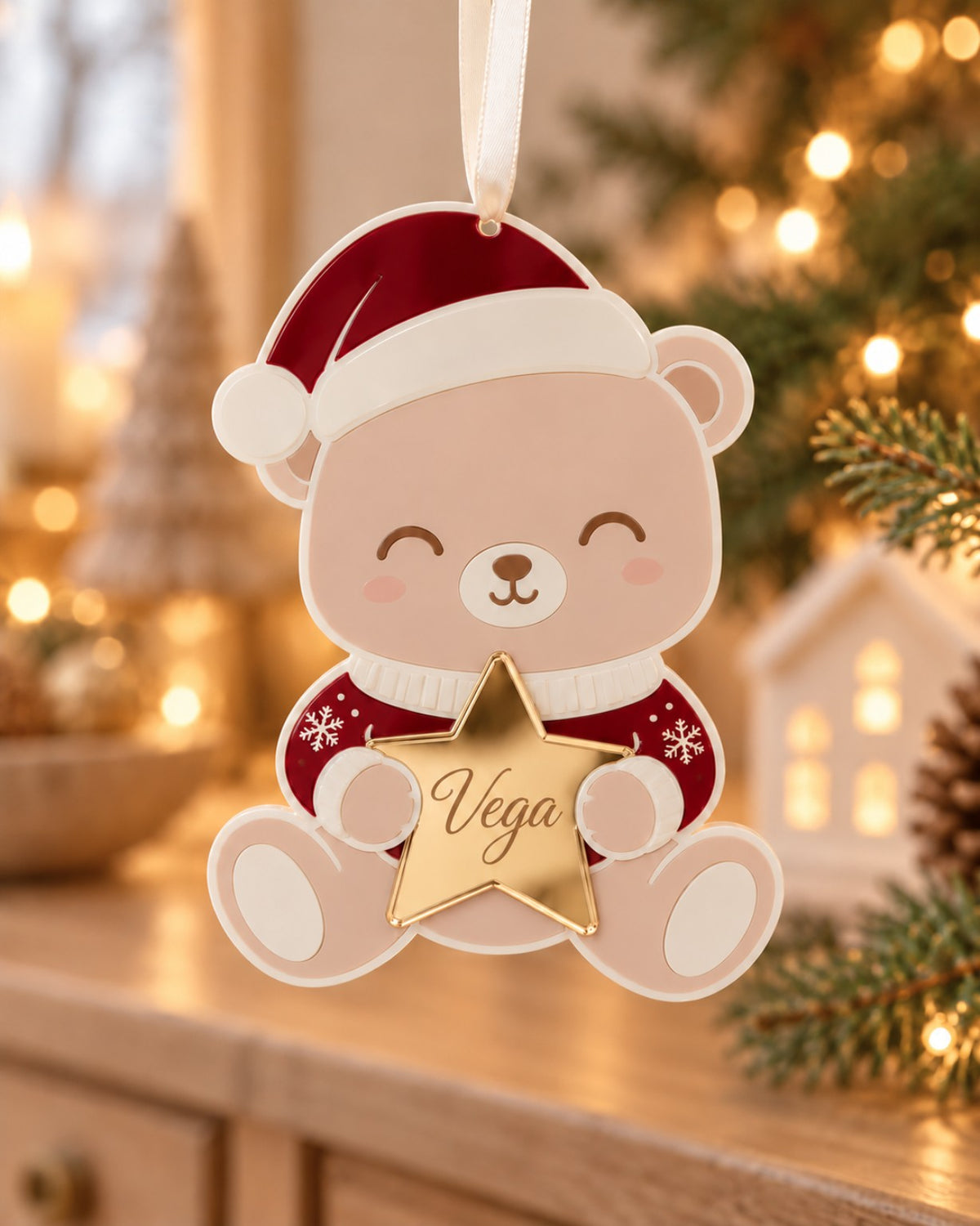 Adorno de Navidad de metacrilato con osito Teddy, gorro rojo y estrella dorada grabada con el nombre Vega.